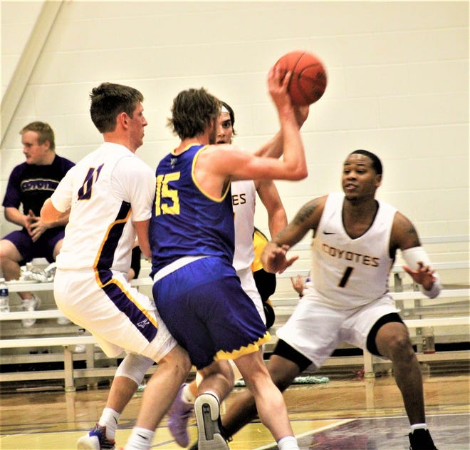 Bethany's Dalton Smyres is surrounded by James Brooks, left, Brayden White and Brendon Ganaway (1) during their Kansas Conference matchup Tuesday night at Mabee Arena. [BAILIE TROLL/SALINA JOURNAL]