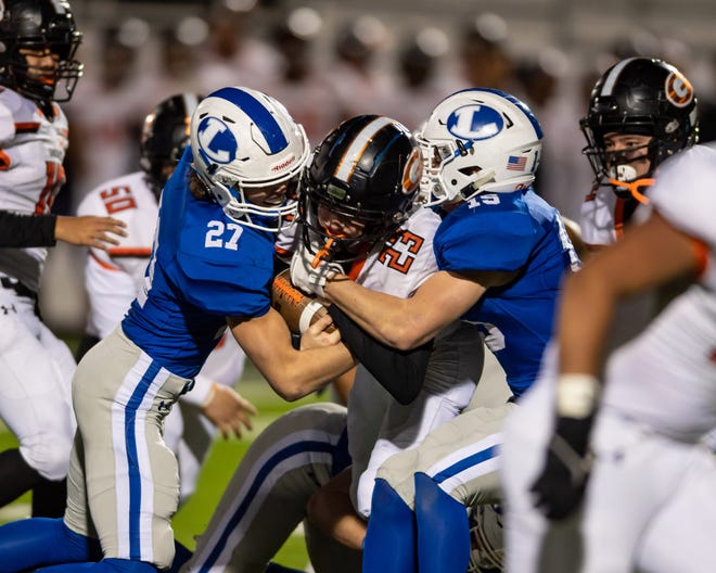 Lampasas defenders Koby Allen, left, and Case Brister tackle Gonzales quarterback Heath Henke during the Badgers’ area round win over Gonzales on Nov. 22. Lampasas faces Needville in the regional semifinals Saturday in San Antonio. [Henry Huey for Statesman]