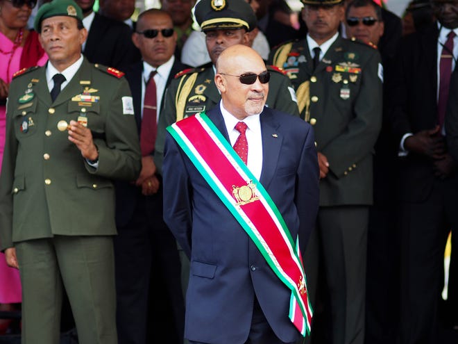 Suriname President Desire "Desi" Delano Bouterse observes an August 2015 military parade, after being sworn in for his second term, in Paramaribo, Suriname. A Suriname court on Friday convicted Bouterse in the 1982 killings of 15 political opponents and sentenced him to 20 years in prison. [ERTUGRUL KILIC/THE ASSOCIATED PRESS]