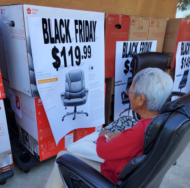 A shopper tests out an office chair in front of the Staples in the Shady Oaks Shopping Center during Black Friday in Ocala. The woman was going through the features of the chair while deciding to buy. [Carlos E. Medina/Staff]