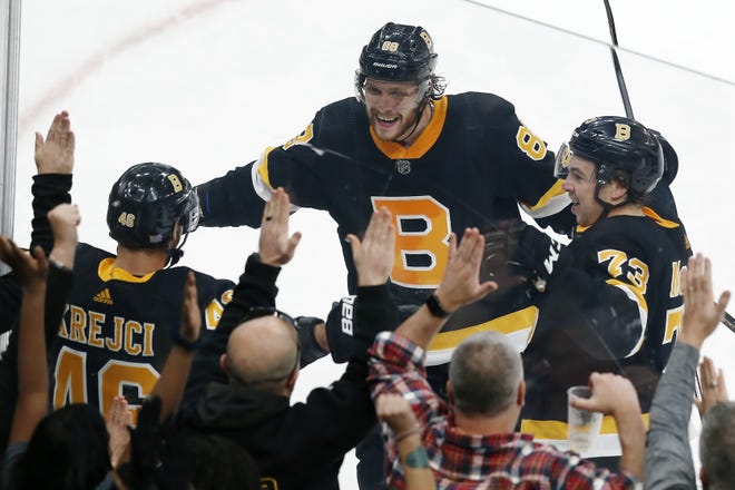 David Krejci celebrates his overtime goal with David Pastrnak, center, and Charlie McAvoy, right, as the Bruins came from two goals back to defeat the Rangers, 3-2, on Friday afternoon. [AP / Michael Dwyer]