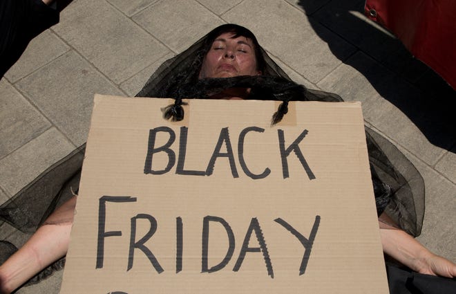 A demonstrator "plays dead" during climate change protest outside the Johannesburg Stock Exchange in Johannesburg Friday, Nov. 29, 2019. Environmentalists around the world are joining a global day of protests Friday, in a symbolic gesture to demand that all governments act against climate change. (AP Photo/Denis Farrell)