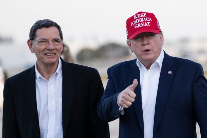 President Donald Trump gives thumbs up as he steps off Air Force One, accompanied by Sen. John Barrasso, R-Wyo., at the Palm Beach International Airport, Friday, Nov. 29, 2019, in West Palm Beach, Fla. Trump is returning from a trip to visit the troops in Afghanistan. (AP Photo/Alex Brandon)