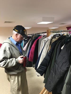 Leo Daigneault, a recorder for the Knights of Columbus, checks over clothing set to be given away Friday during the group’s Coats for Kids event in Brooklyn. [John Penney/ NorwichBulletin.com]