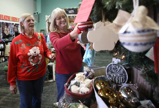 Sisters Sandra Howell and Paula Evans look over ornaments on Friday at The Little Mustard Seed in downtown Panama City. [PATTI BLAKE/THE NEWS HERALD]