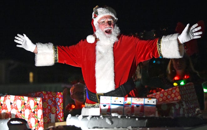 Arriving in style in a boat was Jolly Old Saint Nick while more than a thousand spectators enjoyed the 35th Annual Siesta Key Light Up the Village Parade & Holiday Stroll on Saturday night. [HERALD-TRIBUNE STAFF PHOTO / THOMAS BENDER]