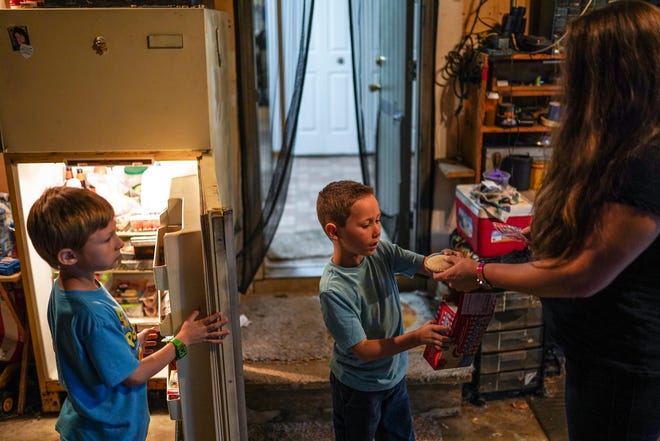 From left, Angela Peters, 32, of Commerce Township gets snacks out for her sons Gabriel Peters, 5, and Dante Hilton, 7, after they arrived home in Commerce Township on Monday, Oct. 21, 2019 from school at Keith Elementary School. Peters says her children often come home wanting snacks due to the lack of time they have to eat and have recess at their school. (Ryan Garza/Detroit Free Press/TNS)