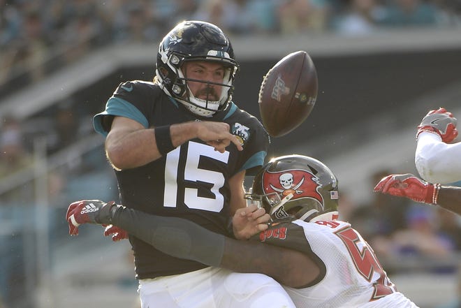 Tampa Bay Buccaneers linebacker Shaquil Barrett, right, hits Jacksonville Jaguars quarterback Gardner Minshew (15) as he throws a pass during the second half Sunday in Jacksonville, Fla. [PHELAN M. EBENHACK/THE ASSOCIATED PRESS]