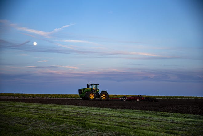 The moon rises over farmer Marty Marr and his tractor and plow May 17 as he pushes to get the soil turned over and ready for corn planting while weather allows along Berlin Tower Road North north of New Berlin May 17. Historic rainfall in the spring prevented farmers from getting seed into the ground until June in some cases. [Justin L. Fowler/The State Journal-Register]