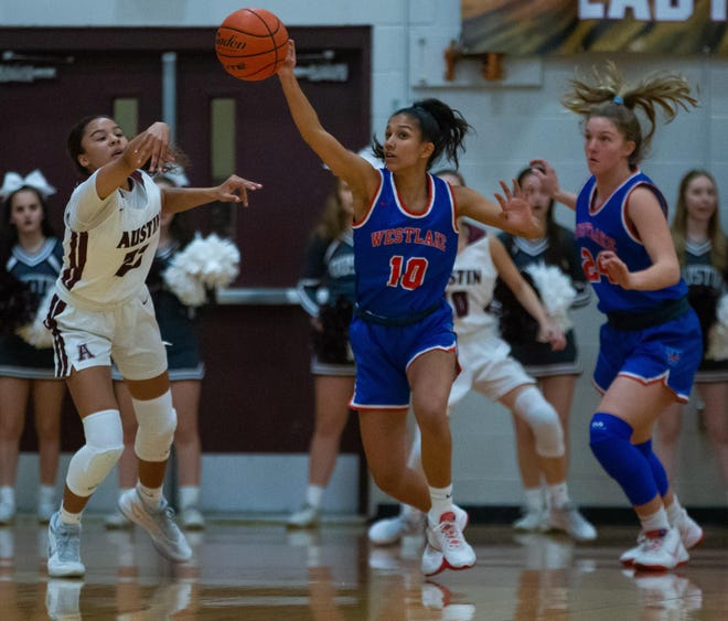 Westlake freshman guard Syona Mandyam deflects the ball away from Austin Maroons guard Shanel Reid during the first period at the District 25-6A district girls basketball game Dec. 3 at Austin High School. [JOHN GUTIERREZ/FOR STATESMAN]