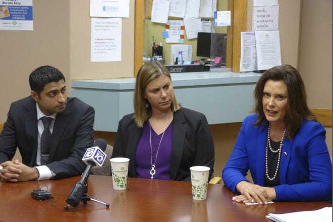 Democratic Gov. Gretchen Whitmer, right, U.S. Rep. Elissa Slotkin, D-Mich., and Dr. Farhan Bhatti, CEO of Care Free Medical, speak at an event to encourage enrollment under the federal health care law on Monday, Dec. 2, 2019, at one of Care Free's clinics in Lansing, Mich. (AP Photo/David Eggert)