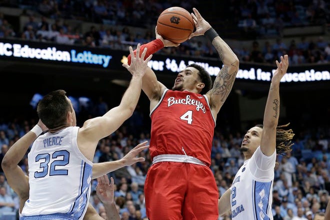 Ohio State's Duane Washington Jr. puts up a shot between North Carolina's Justin Pierce, left, and Cole Anthony, right, during Wednesday night's game at the Smith Center.