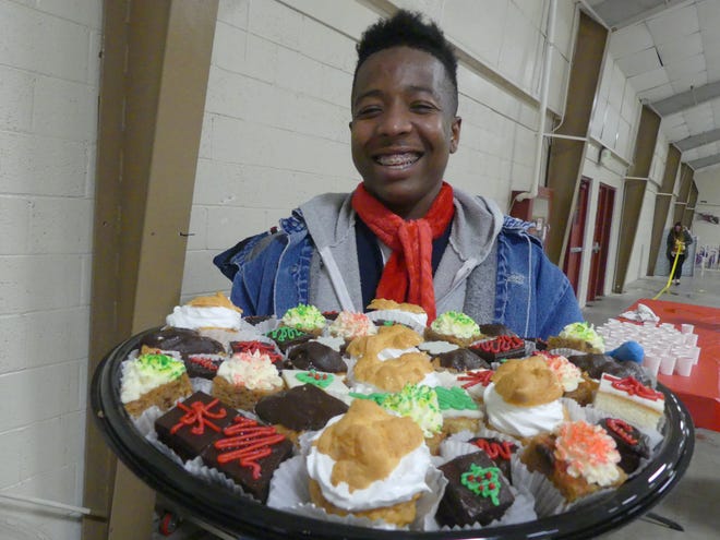 Keyantah Jordan, 19, with the Sheriff’s Culinary Team from the High Desert Detention Center, displays a tray of holiday treats at the 16th annual Doris Davies Memorial Bicycle Giveaway in Victorville. [Rene Ray De La Cruz, Daily Press]