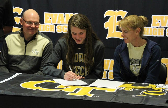 Evans senior Katy Earwood signs a cross-country scholarship to Georgia Tech on Friday in the Evans High School Media Center. Earwood earned an individual Region 3-AAAAAA title and appeared in the Georgia High School Association state meet. [WILL CHENEY/THE AUGUSTA CHRONICLE]