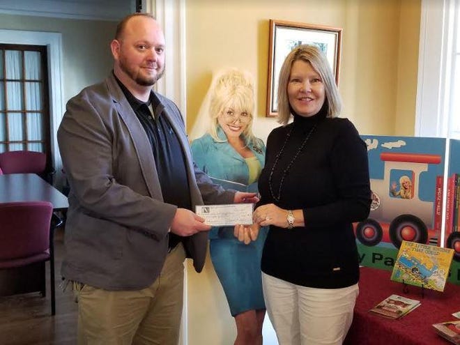 Chad Conville, left, presents Lisa Hayworth with $385 for Dolly Parton’s Imagination Library. [Contibuted photo]