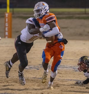 Randleman’s Dominick Poole tries to break free from Salisbury's Jalon Walker Friday night in the NCHSAA 2AA East Regional playoff game at RHS. [PAUL CHURCH/THE COURIER-TRIBUNE]