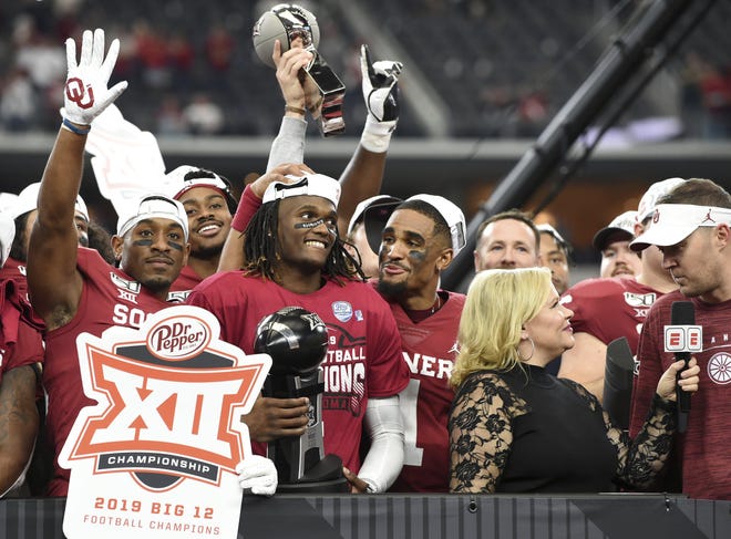 Oklahoma wide receiver CeeDee Lamb (center, holding the MVP award after the Big 12 championship game Saturday) and his teammates will face LSU in the College Football Playoff semifinals. [Jeffrey McWhorter/The Associated Press]