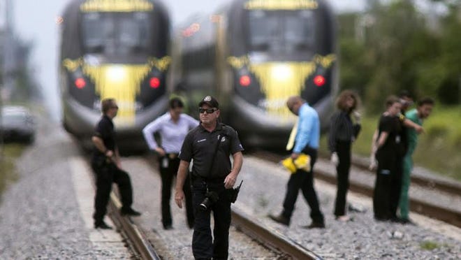 Police investigate a dead body on the train tracks south of Woolbright Road that appears to have been struck by a Brightline train. [Damon Higgins / The Palm Beach Post]