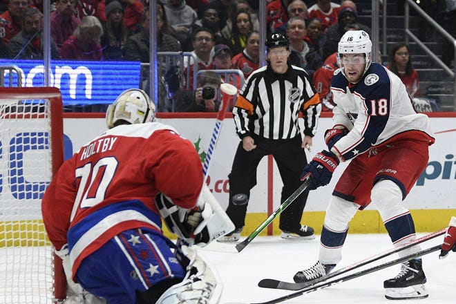 Columbus Blue Jackets center Pierre-Luc Dubois (18) shoots the puck towards Washington Capitals goaltender Braden Holtby (70) during the second period of an NHL hockey game, Monday, Dec. 9, 2019, in Washington. (AP Photo/Nick Wass)