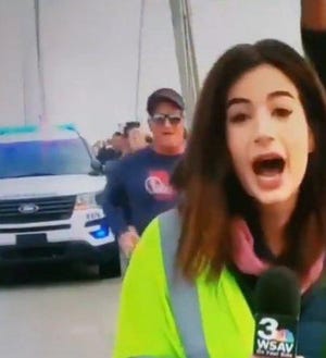 This is a screenshot of the video where WSAV reporter Alex Bozarjian is reporting live on the Talmadge Memorial Bridge when the man behind her with the sunglasses runs past her and slaps her buttocks.