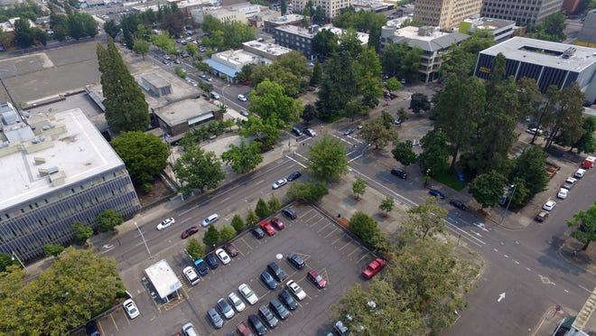 This drone's-eye view shows the locales central to the city of Eugene's new Town Square concept. In the foreground is the county-owned "butterfly" parking lot, the planned home for the new City Hall and year-round Lane County Farmers Market. In the middle and to the right is the Park Blocks. At left, the vacant City Hall block is visible. [Rob Romig/The Register-Guard] - registerguard.com