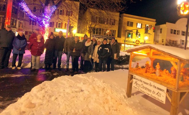 Members of the Knights of Columbus and of St. Therese of Lisieux Parish gathered for the annual lighting of the Christmas creche in Central Park on Main Street in Sanford earlier this month. [Manny Deamaral photo]