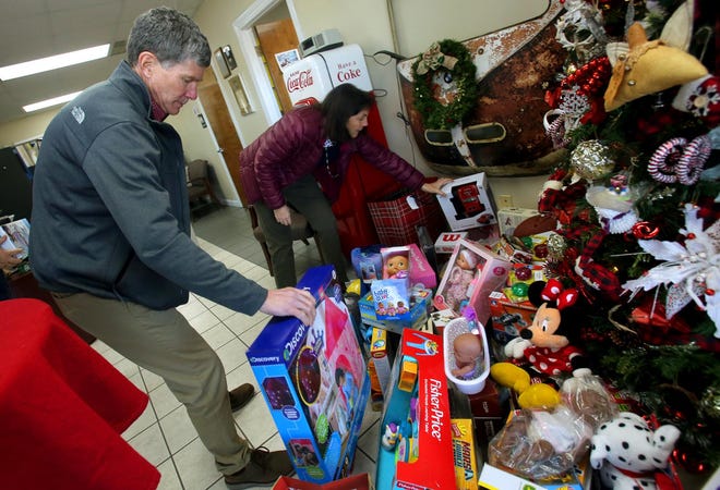 J&E Sales customers place toys by the tree on Thursday. [Brittany Randolph/The Star]