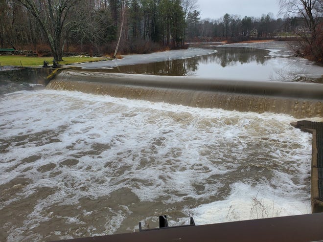 The Mill Pond Dam in Durham was overflowing as water from the swollen Oyster River gushed over it around mid-day on Saturday. [Jeff McMenemy photo]
