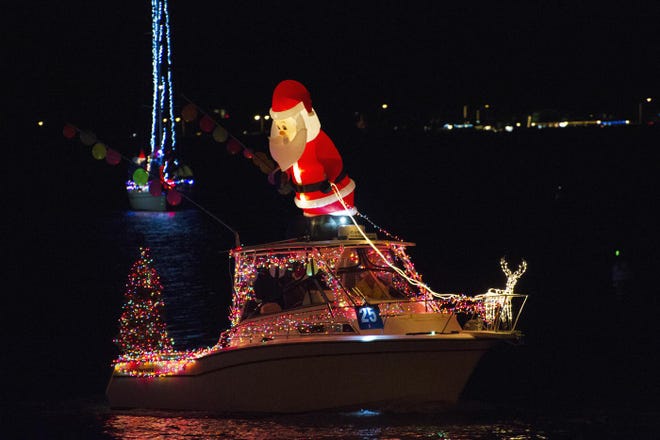 A boat carrying an inflatable Santa Claus makes its way around the bayfront during the 2017 St. Augustine Yacht Club’s annual Regatta of Lights parade. [FILE]