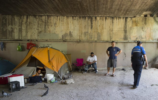 Austin police officer Vanessa Jimenez, at right, regularly interacts with people living on the streets in downtown Austin as she makes her rounds. The Supreme Court on Monday let stand a ruling that prohibited camping bans aimed at those experiencing homelessness. [Ricardo B. Brazziell/AMERICAN-STATESMAN FILE]