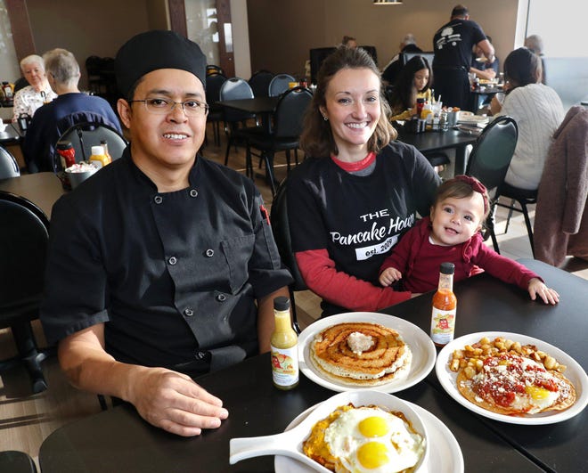 Chef Jose Araujo, left, sits in the newest Pancake House location and shows some of the offerings with co-owner Janell Rando and her 1-year-old daughter, Giulia. [Fred Squillante/Dispatch]