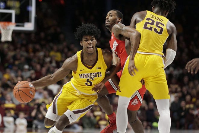Minnesota's Marcus Carr takes advantage of a pick by Daniel Oturu to get past Ohio State&rsquo;s Luther Muhammad. Carr scored a career-high 35 points against the Buckeyes. [Andy Clayton-King/The Associated Press]