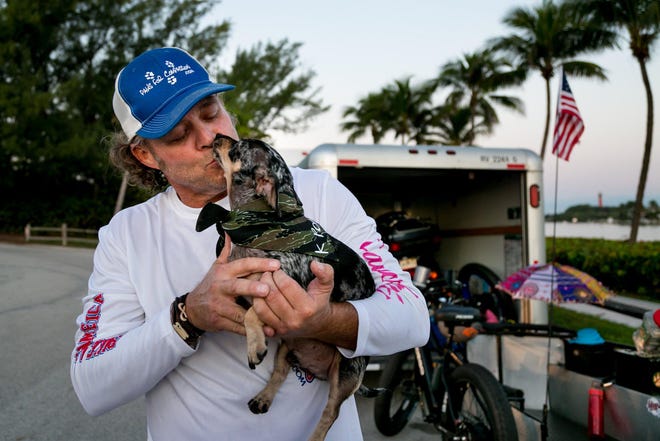 Jay Hamm, biking across the U.S. with his two dogs, K Poppy (seen here) and Chibby Choo to raise awareness of pet therapy, prepares to leave from the Jupiter inlet on Friday November 1, 2019. [RICHARD GRAULICH/palmbeachpost.com]