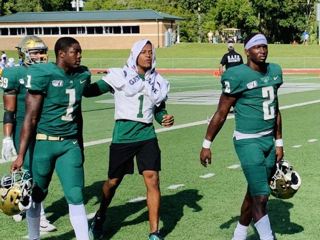 Jacksonville University quarterback Calvin Turner Jr. (2) leaves the field with wide receiver B.J. Byrd (1, green) after the Dolphins lost to Morehead State 30-22 on Oct. 12. [GARRY SMITS/THE FLORIDA TIMES-UNION]