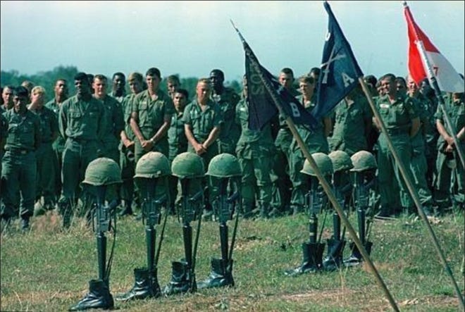 U.S. soldiers hold a memorial service for seven men of the U.S. 101st Airborne Brigade in a clearing near a former French rubber plantation in Lai Khe, Vietnam, Dec. 1965. Their boots, helmets and M16 rifles are set up with a field altar. The seven paratroopers were killed in action during a search-and-destroy mission against the Viet Cong in the jungles and plantation areas of Lai Khe, about 40 miles north of Saigon, during the Vietnam War. (AP Photo/Henri Huet)