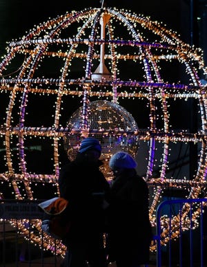A couple stop Monday, Dec. 31, 2018, in front of the giant, light-adorned ball at Opening Night 2019 in Bicentennial Park in downtown Oklahoma City. The ball raises for the countdown to midnight every year as part of the New Year's Eve festivities.