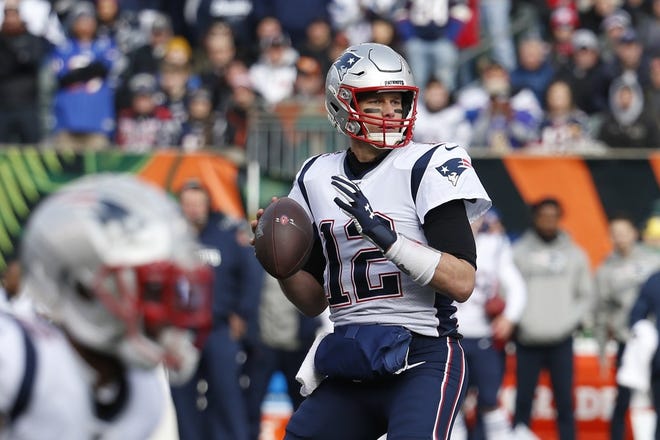 Patriots quarterback Tom Brady looks to pass before throwing for a touchdown in the first half against the Bengals on Sunday in Cincinnati.