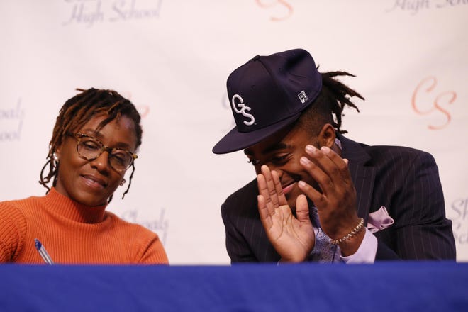 Cedar Shoals senior Jalen Jackson reacts as his mother Andrea Wynn signs onto his athletic scholarship to play football at Georgia Southern University on Wednesday. [Photo/Joshua L. Jones, Athens Banner-Herald]