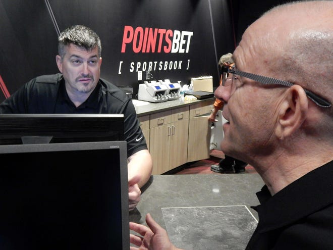 PointsBet supervisor Estel Walker, left, listens Saturday as manager Patrick Hascall discusses the official opening of the sports-betting room in August at Catfish Bend Casino. [Bob Saar/thehawkeye.com]
