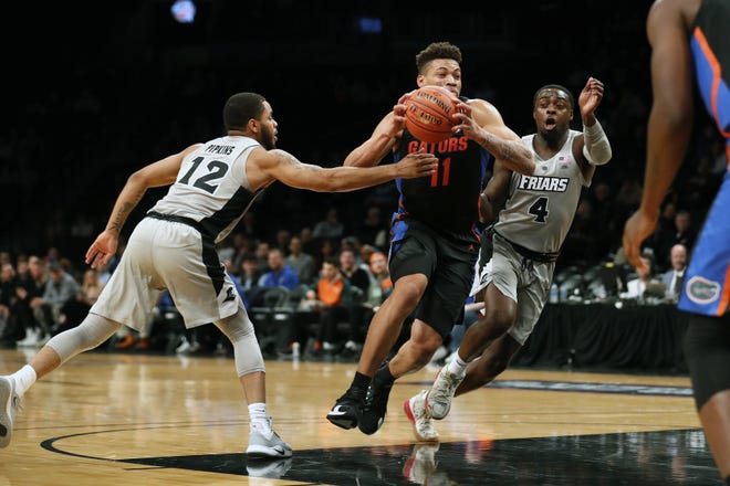 Florida Gators forward Keyontae Johnson drives against Providence Friars guard Luwane Pipkins and Providence Friars guard Maliek White during the first half at Barclays Center on Tuesday in New York. [Michael Owens/The Associated Press]