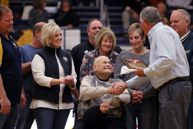 Bob Brueck surrounded by family is inducted into the Notre Dame Hall of Fame along with with wife, Martha, prior to the start of the Notre Dame High School's boys game against New London High School Tuesday at Notre Dame's Father Minett Gymnasium. [John Lovretta/thehawkeye.com]