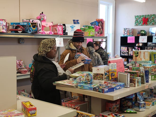 Jennifer Wallace and Nicholas George, both of Adrian, pick out toys for their daughter Thursday at Associated Charities. The two were among over 450 families helped this week during the organization’s annual Christmas program where donated toys and food are given to needy families. [Telegram photo by Spencer Durham]