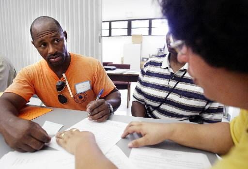An ex-felon listens to a volunteer from the American Civil Liberties Union as she explains how to apply for restoration of his civil rights including voting at a workshop in Apopka. [AP Archives/Scott Audette]