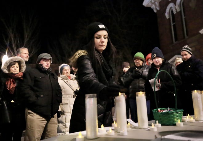 Katie Mackle, IDN care coordinator, lights a candle in remembrance of a person who passed away this year at the Cross Roads House memorial candlelight vigil held in front of the North Church Friday night.
[Ioanna Raptis/Seacoastonline]