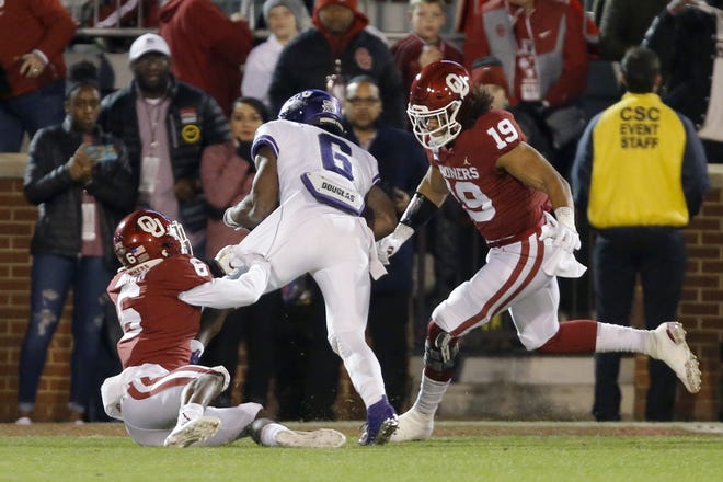 Oklahoma’s Caleb Kelly (19) and Tre Brown (6) bring down TCU’s Darius Anderson during a Nov. 23 win at Owen Field. OU coach Lincoln Riley is uncertain about Kelly’s playing status for the Peach Bowl. [Bryan Terry/The Oklahoman]