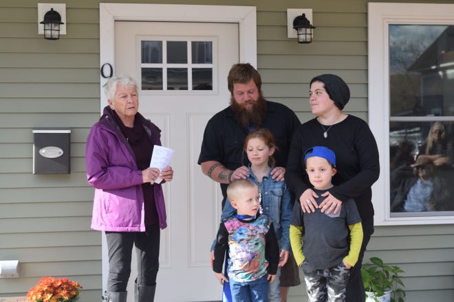 Beth Doty, left, of Habitat for Humanity, joins Rich and Missy Lathrop and their children, Dylan, Silas and Forrest, on the front porch of their brand-new home during a celebration of its completion in November. [COURTESY PHOTO]