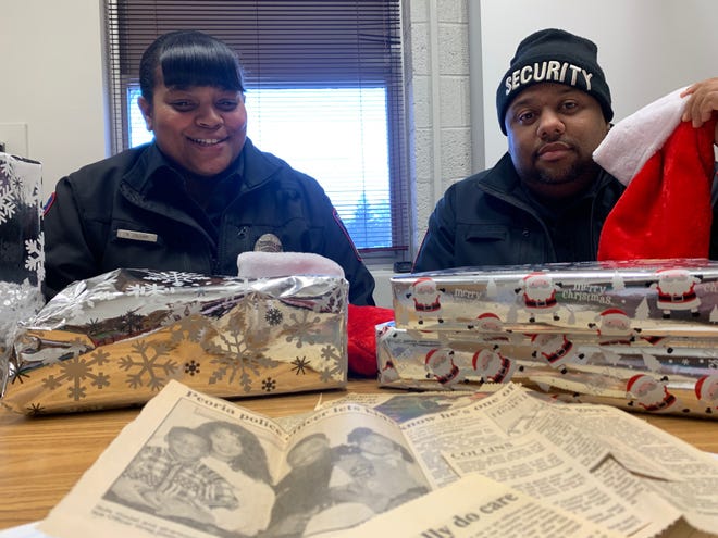 Breonna Collins and Kwan O’Neal, both school resource officers with Peoria Public Schools, sit with presents Friday that they delivered to students at Trewyn Middle School. [GRACE BARBIC/JOURNAL STAR]