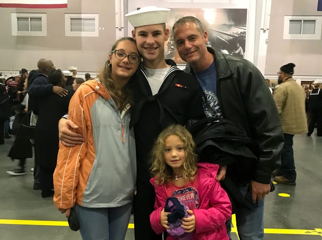 In this Nov. 22, 2019 photo provided by the Walters Family, Cameron Walters, center in Navy uniform, poses for a photo with his sisters, Lily Walters, left, and Shania Walters, right, and his father, Shane Walters, far right, the day he graduated from boot camp in Great Lakes, Ill. Cameron Walters, 21, of Richmond Hill, Georgia, was among three sailors killed at Naval Air Station Pensacola in Florida on Friday, Dec. 6. (Heather Walters/Courtesy of the Walters Family via AP)