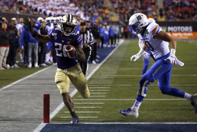 Washington running back Salvon Ahmed makes it into the end zone ahead of Boise State safety Kekoa Nawahine in the first half of the Las Vegas Bowl on Saturday night. [Steve Marcus/The Associated Press]