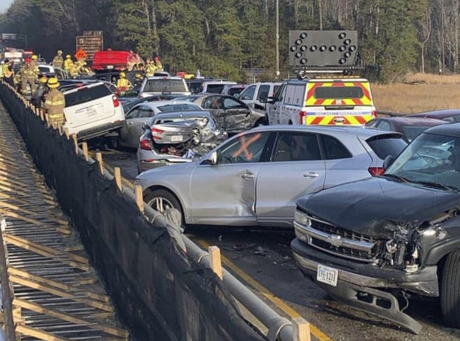 In this photo provided by the Virginia State Police, emergency personnel work the scene of a multi-vehicle pileup on Interstate 64 in York County, Va., on Sunday, Dec. 22, 2019. (Virginia State Police via AP)